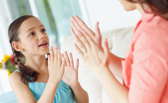 Niña de primaria practica aprendizaje auditivo con mamá