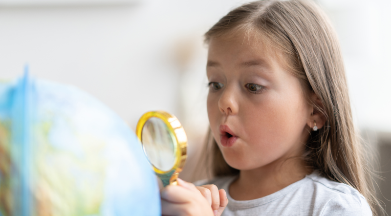 Niña realizando aprendizaje por descubrimiento con un globo terráqueo