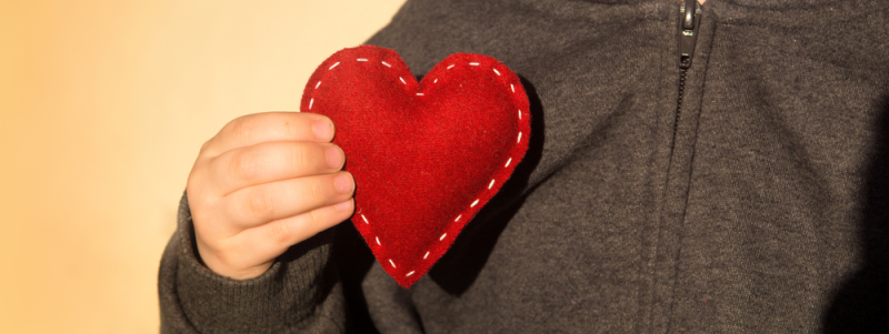 Niño bondadoso sostiene corazón