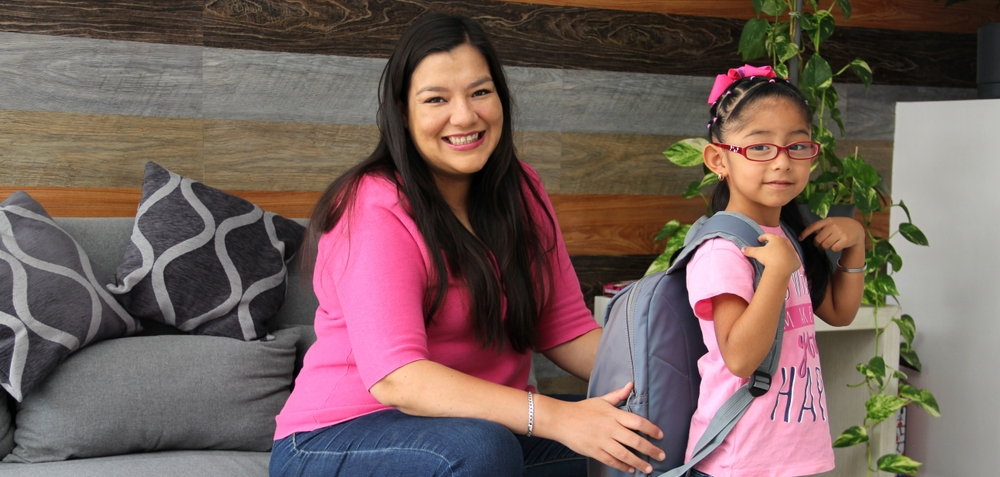 Mamá ayuda a hija a despedirse de preescolar