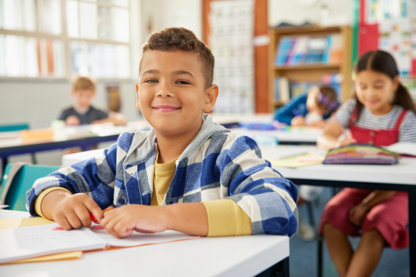 Niño contento en aula por inicio de clases