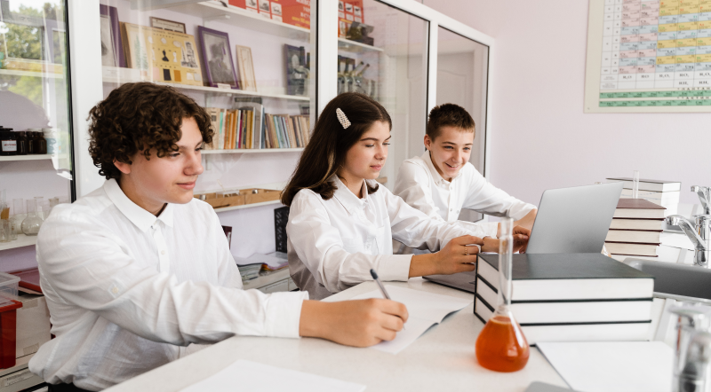 Alumnos de secundaria haciendo investigación en el aula