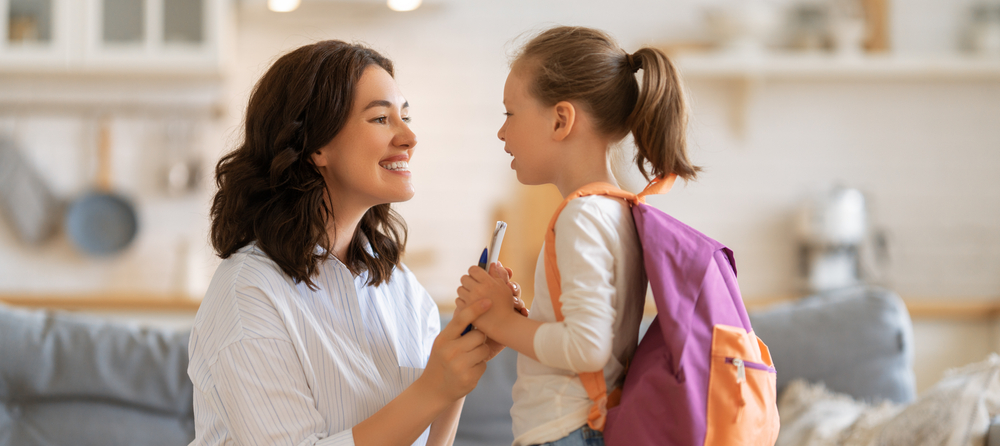 Mamá alista a su niña para la escuela