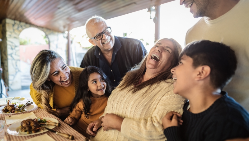 Familia alegre convive y ríe en mesa