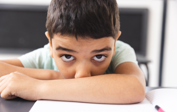 Niño con bajo rendimiento escolar distraído en clase