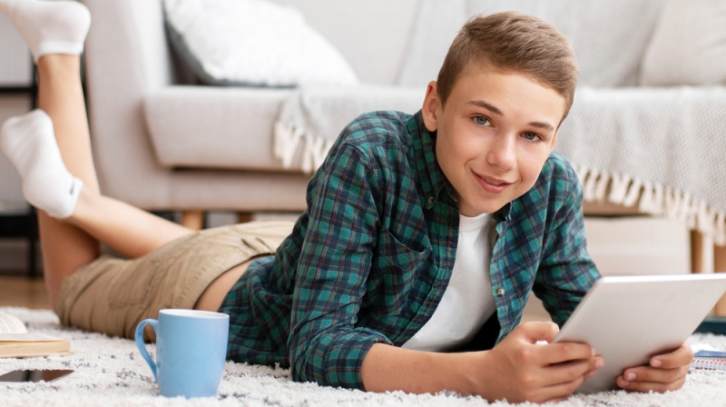 Adolescente en casa con dispositivo tecnológico