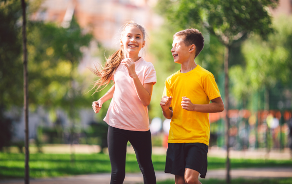 Niños realizando ejercicio corren en el parque