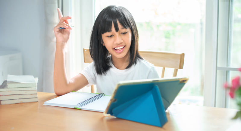 Niña utilizando y divirtiéndose con sitio web educativo