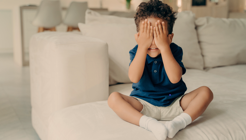 Niño que expresa frustración cubriéndose los ojos