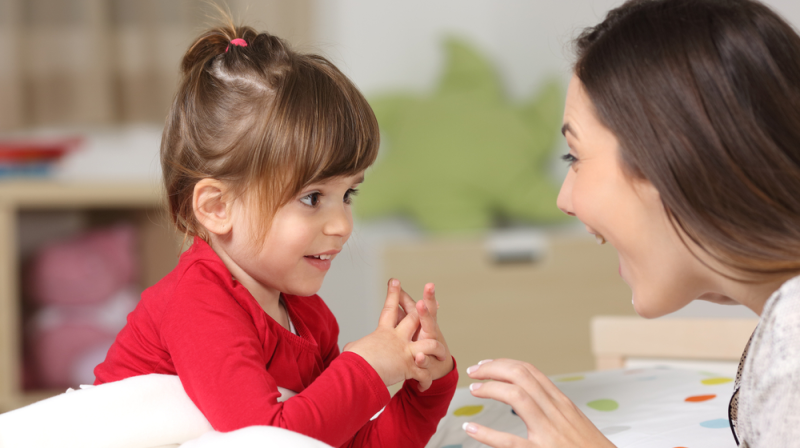 Niña de preescolar aprende trabalenguas con su mamá